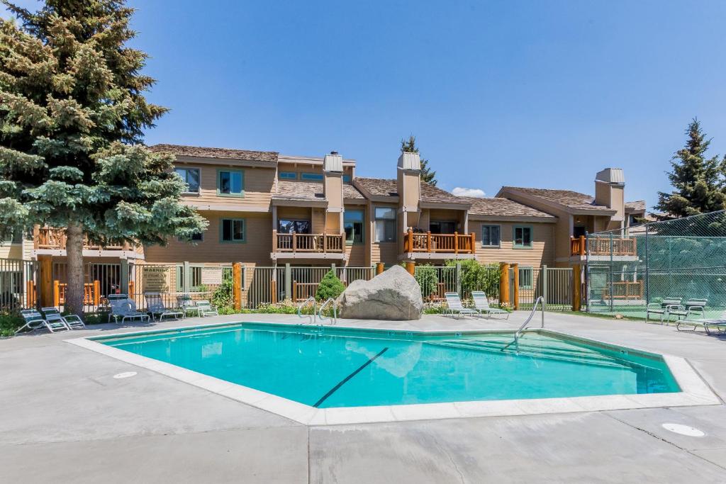 a swimming pool in front of a large house at Mammoth Creek Condos in Mammoth Lakes