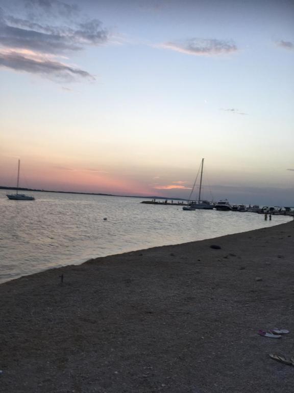 einen Strand mit Booten im Wasser bei Sonnenuntergang in der Unterkunft Apartment Matic in Vrsi