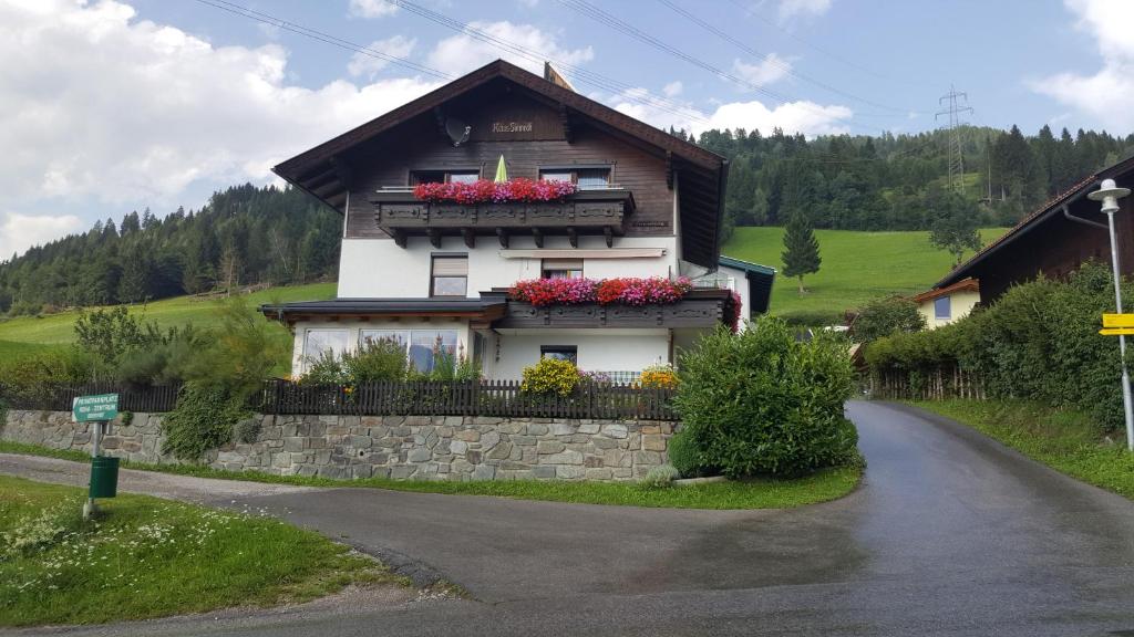 a house with flower boxes on the side of a road at Ferienwohnung Bernsteiner in Iselsberg