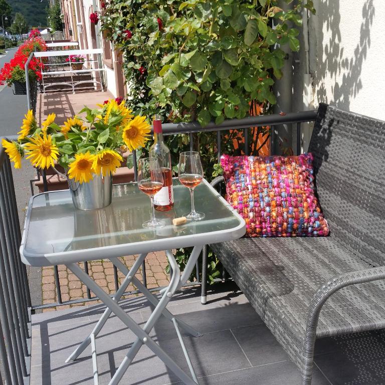a table with glasses of wine and a vase of sunflowers at ferienhaus-raju-zeltingen in Zeltingen-Rachtig