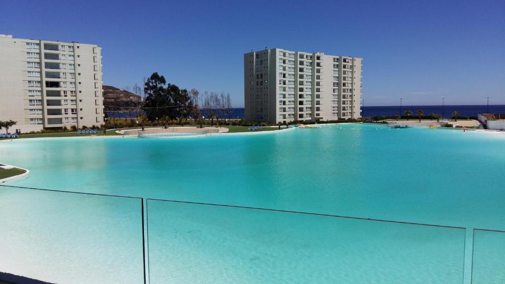 una grande piscina di fronte a due edifici alti di Papudo Laguna VISTA AL MAR Y PISCINA a Papudo