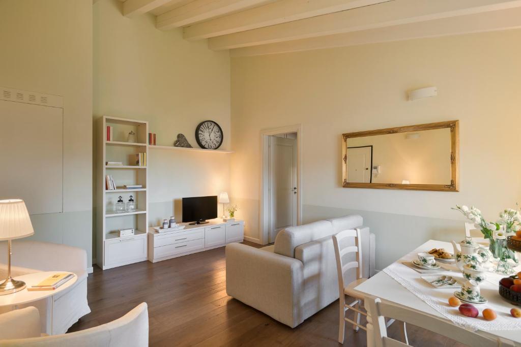 salon ze stołem jadalnym i salon z lustrem w obiekcie Appartamenti Palazzo Scolari w mieście Polpenazze del Garda
