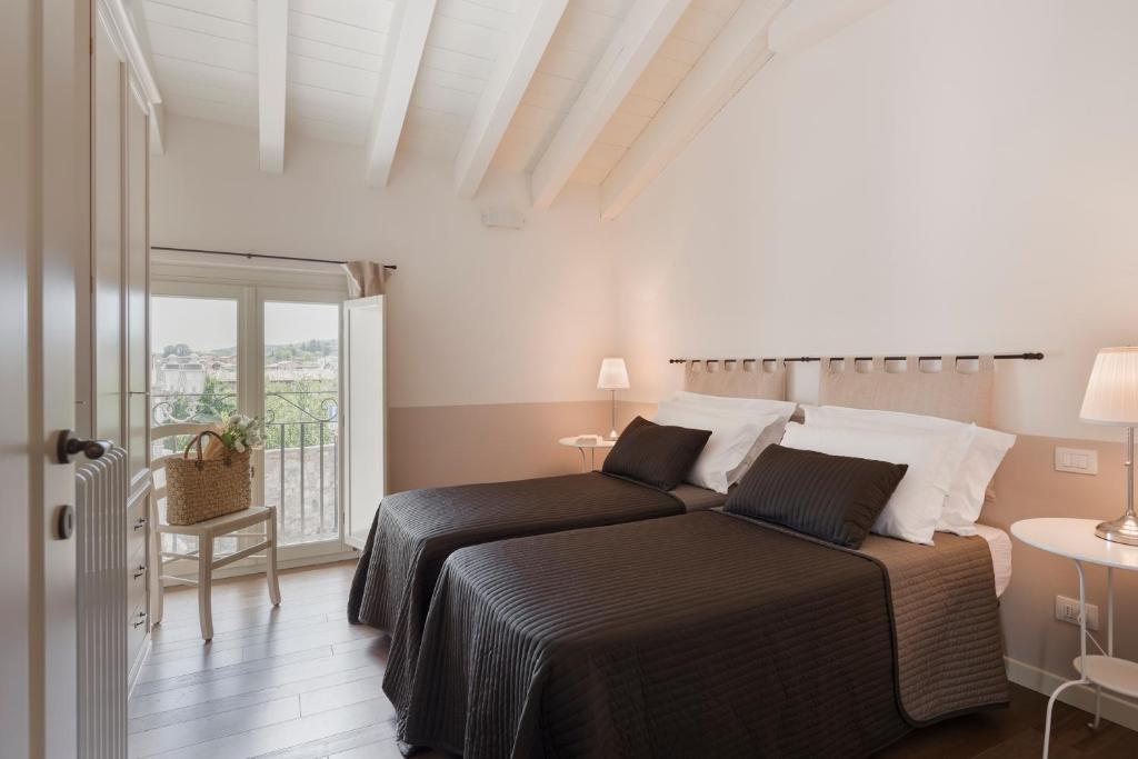 sypialnia z łóżkiem i balkonem w obiekcie Appartamenti Palazzo Scolari w mieście Polpenazze del Garda