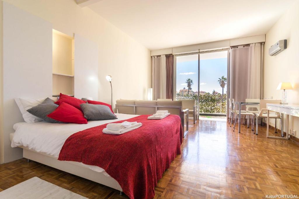 um quarto com uma cama grande e almofadas vermelhas em Arcadas Delight em Estoril