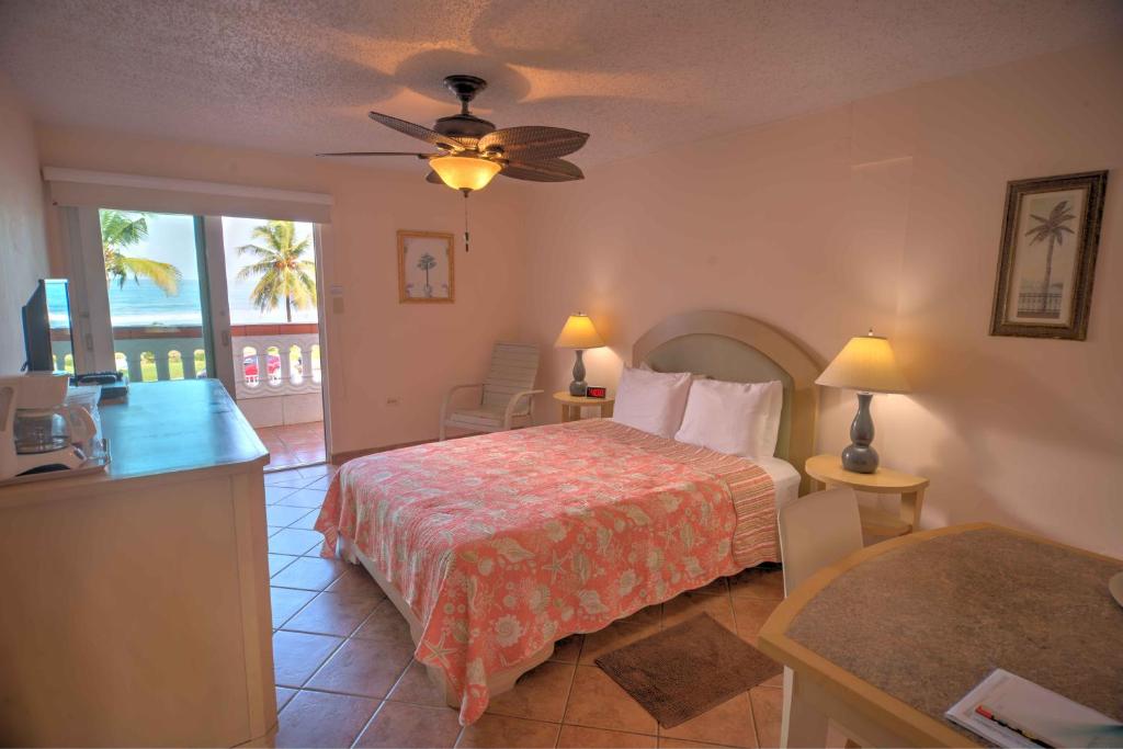 Cet appartement comprend une chambre avec un lit et une table ainsi qu'une cuisine. dans l'établissement Luquillo Sunrise Beach Inn, à Luquillo