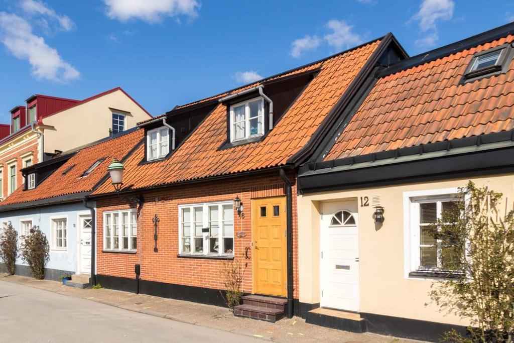 uma fila de casas com telhados laranja numa rua em Charming townhouse em Ystad