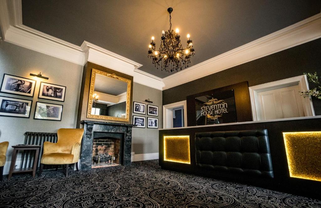 a living room with a fireplace and a mirror at Steventon House Hotel in Abingdon