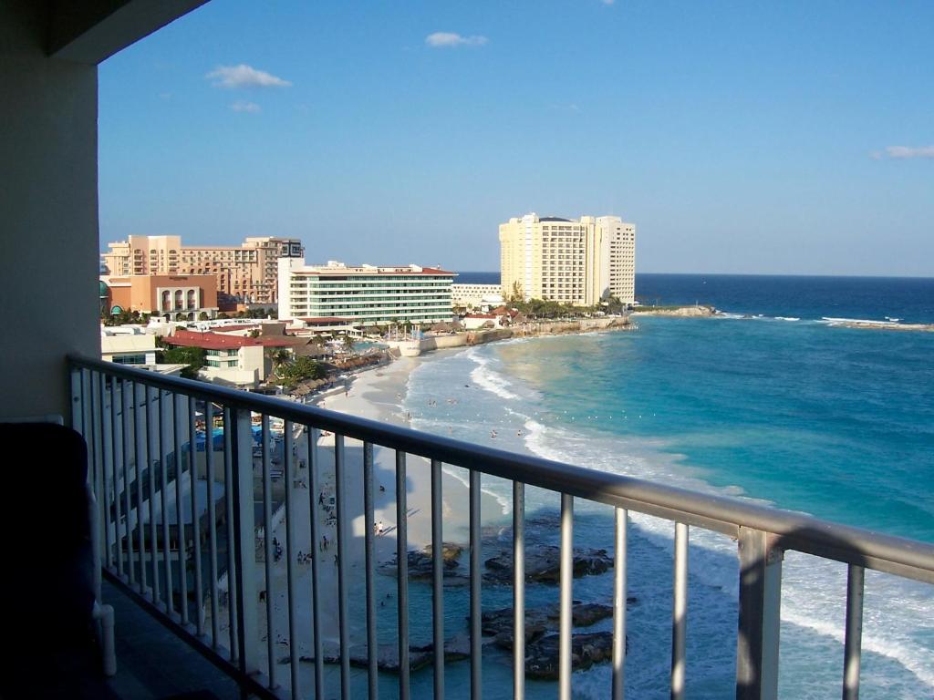 a balcony with a view of the ocean and buildings at Salvia Cancun Aparts in Cancún
