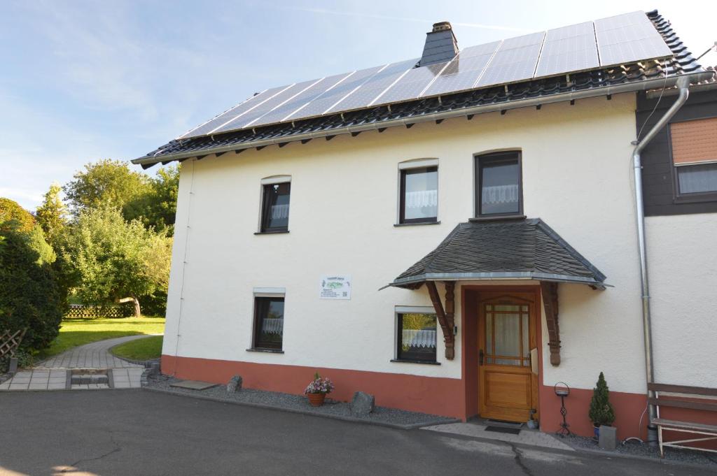 a white house with solar panels on the roof at Ferienwohnung Lampertstal in Alendorf, Toskana der Eifel in Blankenheim