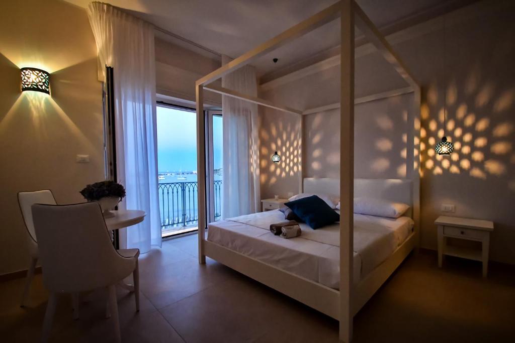 a bedroom with a canopy bed and a balcony at B&b Lungomare Otranto in Otranto
