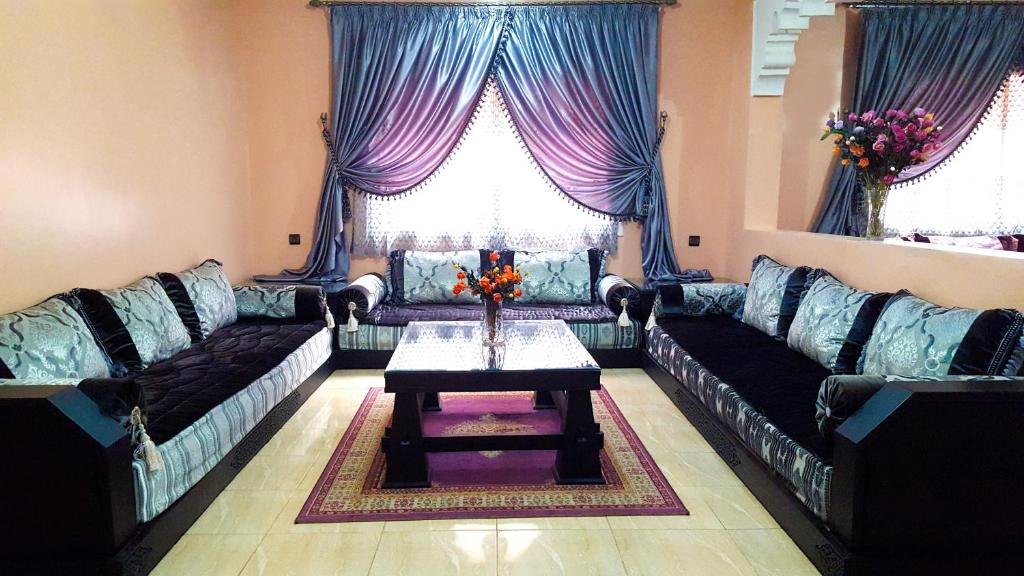 a living room with couches and a table in the middle at Villa Annakhil in Marrakesh