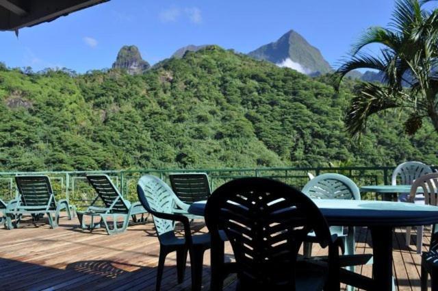 einen Tisch und Stühle auf einer Terrasse mit einem Berg in der Unterkunft Le Relais de la Maroto in Pirae