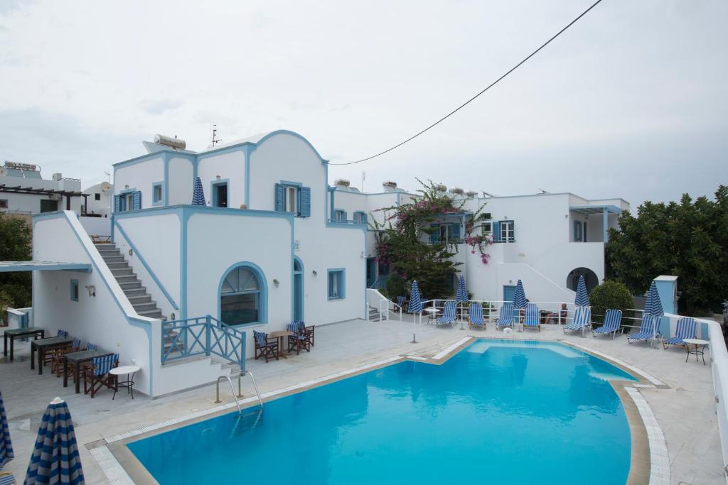 una piscina frente a una casa con edificios blancos en Preka Maria, en Kamari