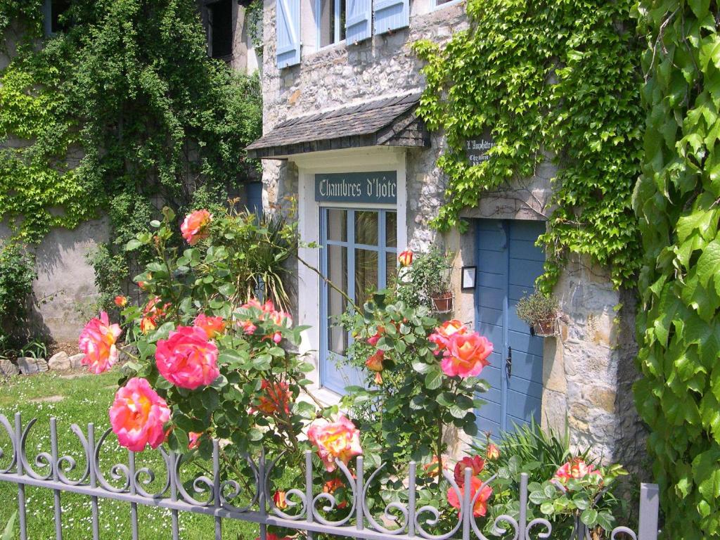 a stone house with a blue door and flowers at B&B Amphitryon in Oloron-Sainte-Marie