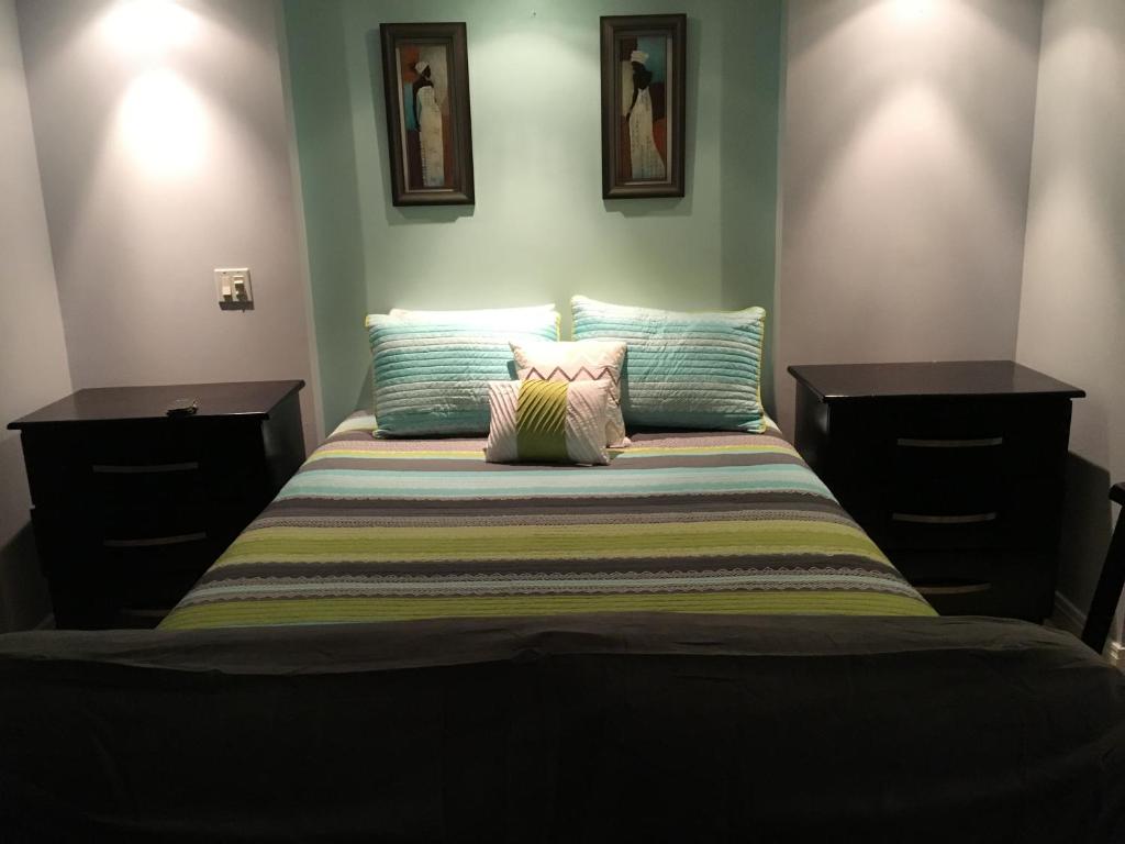 sypialnia z łóżkiem z 2 komodami i 2 poduszkami w obiekcie Anna's Joye Seawind - Freeport, Montego Bay w mieście Montego Bay