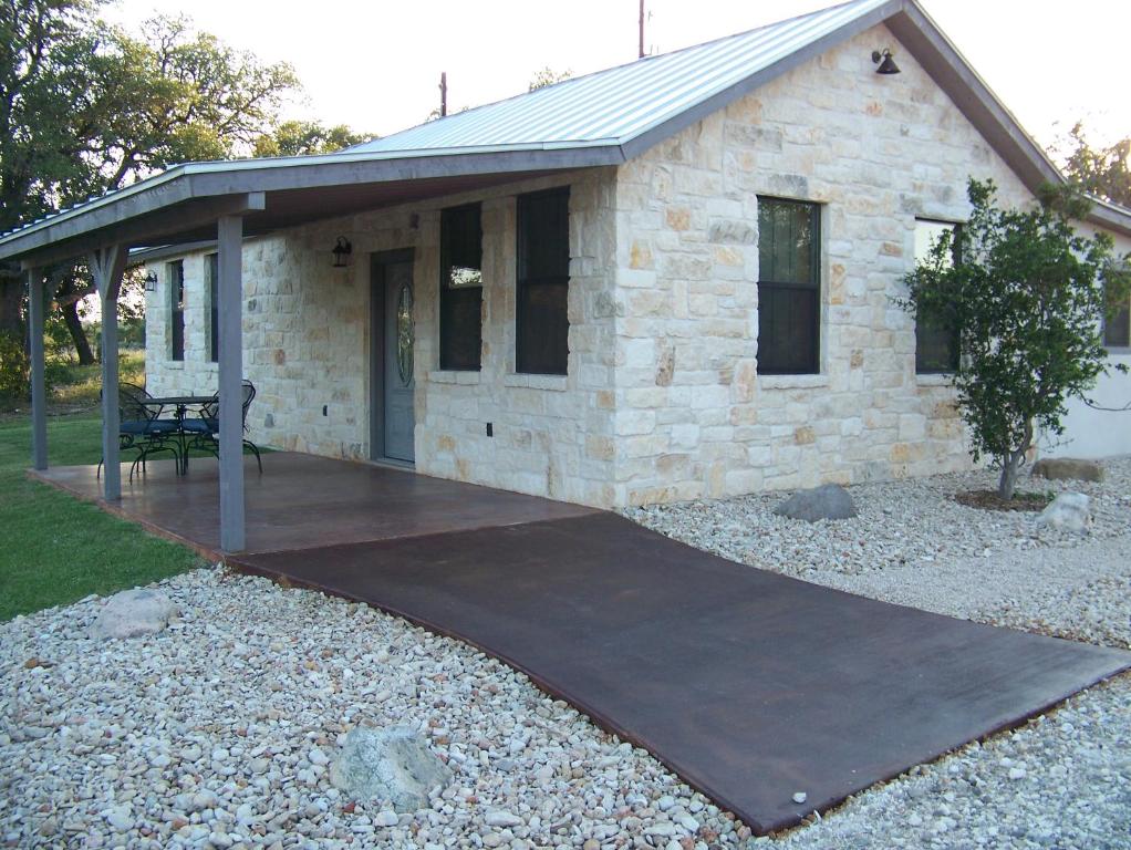 um pátio em frente a uma casa de pedra em Breezy Hills Cottages - Moonlight Cottage em Fredericksburg