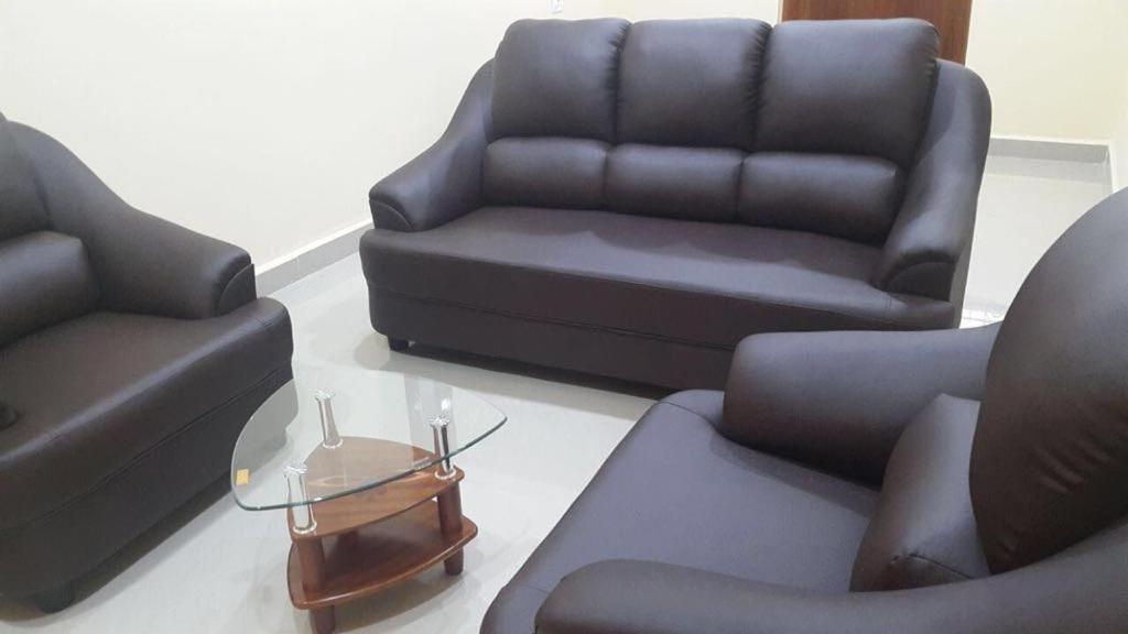 a living room with two chairs and a couch at Avvairam Service Apartment - C9 in Chennai
