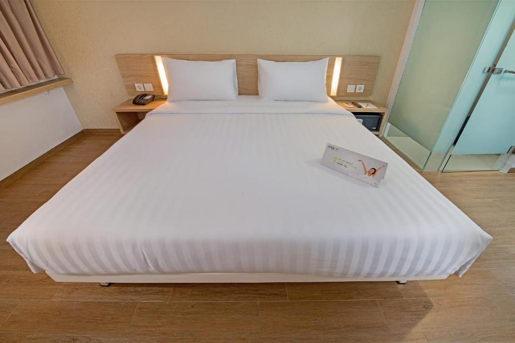 Postel nebo postele na pokoji v ubytování Whiz Prime Hotel Pajajaran Bogor