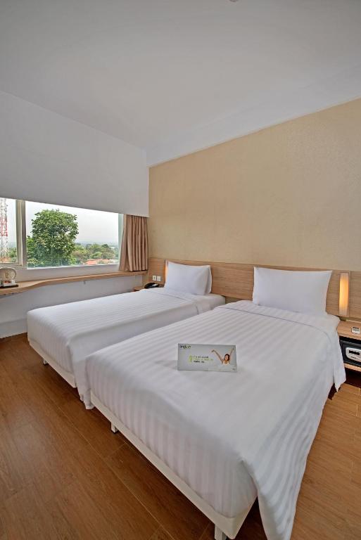Postel nebo postele na pokoji v ubytování Whiz Prime Hotel Pajajaran Bogor