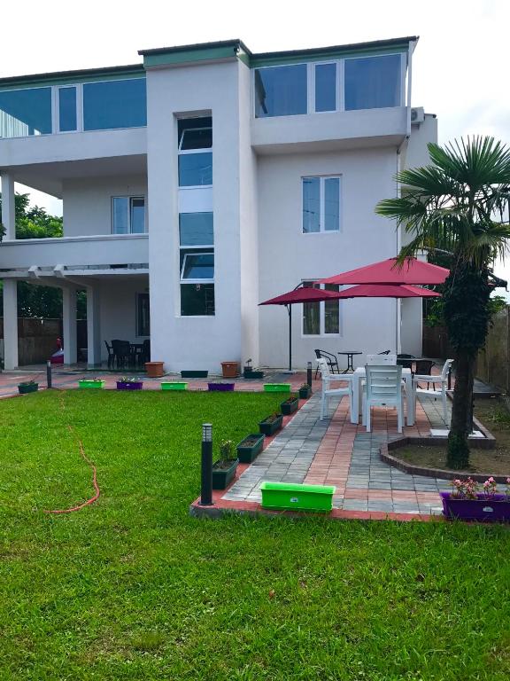 a building with a patio with a table and a tree at BSG Rustaveli 184 in Kobuleti