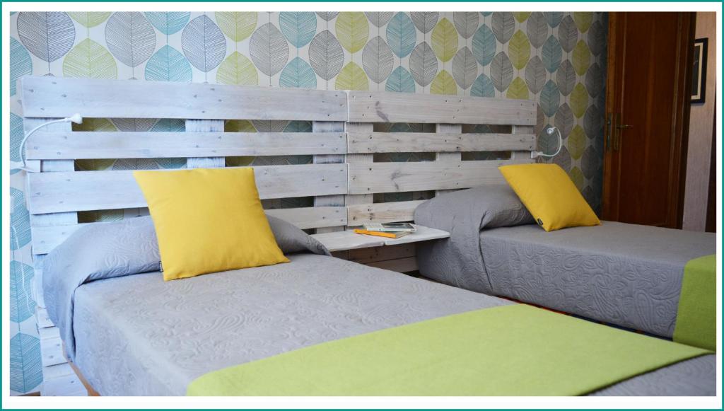 ローマにあるAppartamento Cinecittàの黄色い枕付きのベッド2台が備わる客室です。