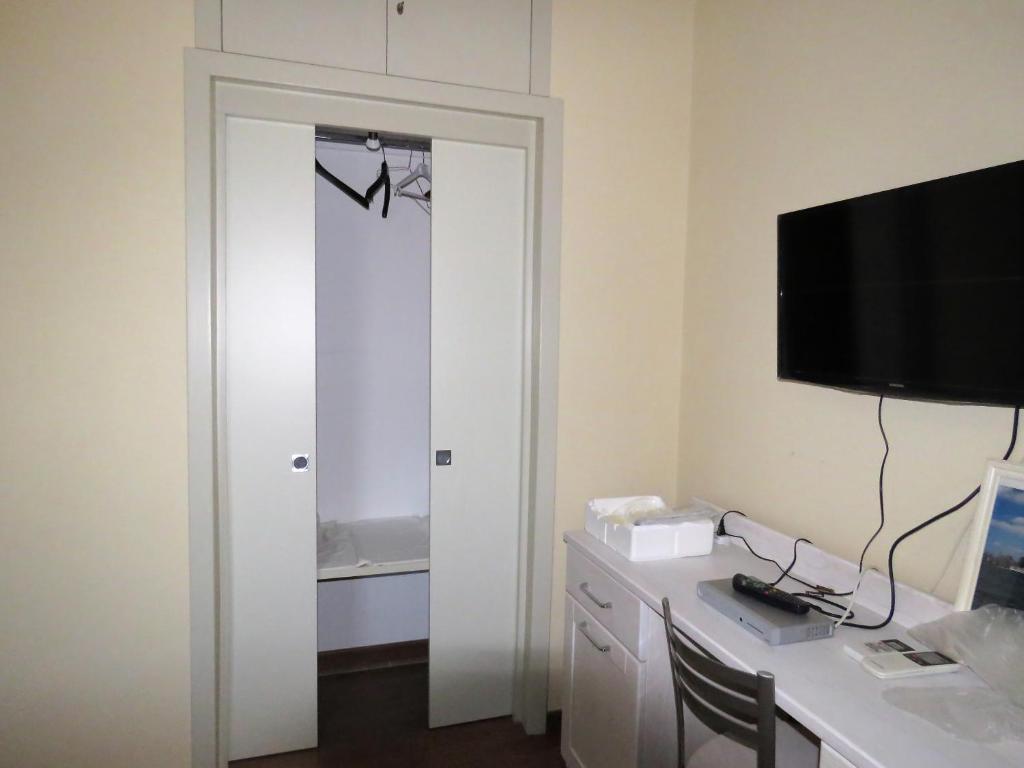 a room with a desk with a computer and a television at B&B Le Rose del Tirreno in Falerna