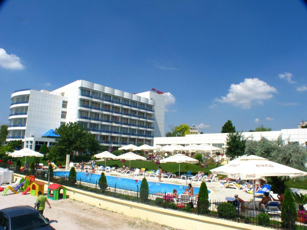 een zwembad met parasols en mensen in een resort bij Hotel Afrodita in Venus