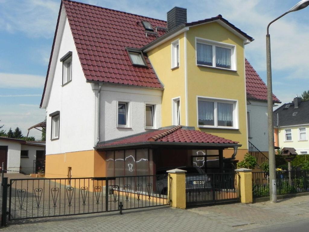 a yellow and white house with a red roof at Ferienunterkuenfte Schulz in Ahlbeck