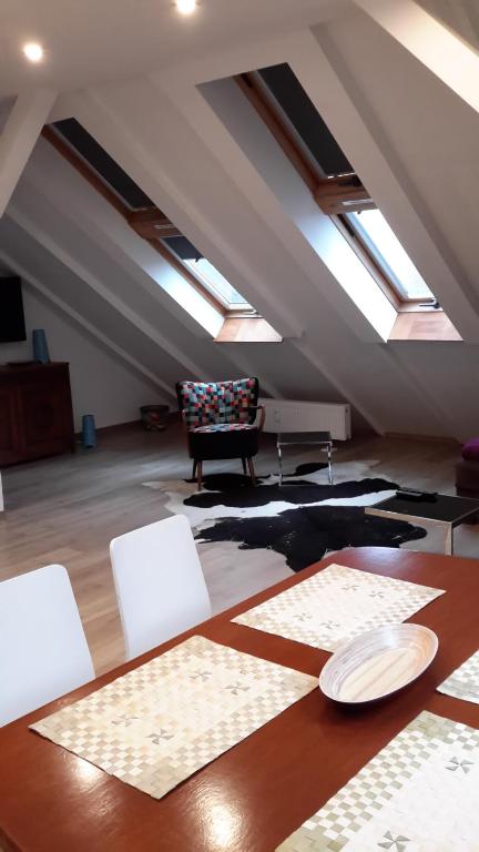 een kamer met een tafel en stoelen en dakramen bij Apartament Loft DeLuxe Koszalin in Koszalin