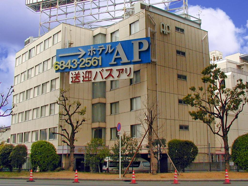 a building with a blue sign on the side of it at Hotel A.P in Toyonaka
