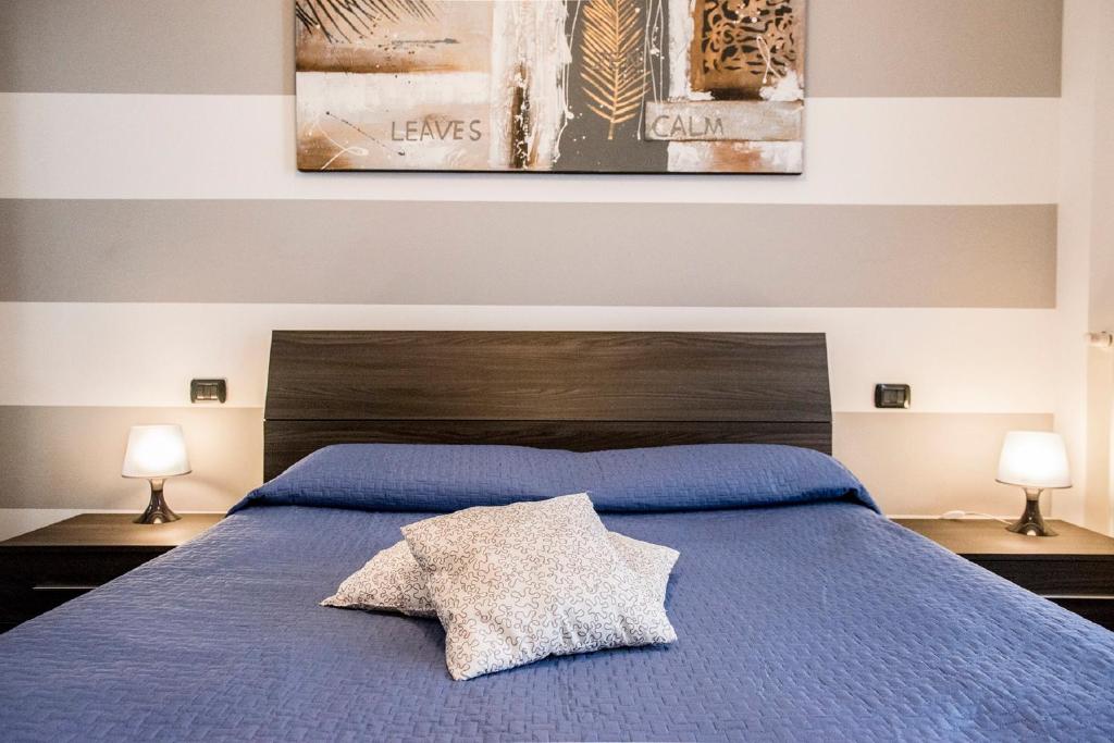 1 dormitorio con 1 cama azul y 2 lámparas en Casa Borgone, en Turín