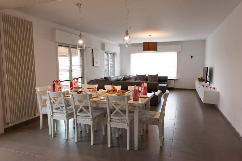 een keuken en eetkamer met een tafel en stoelen bij De Witte Parel in Oostduinkerke