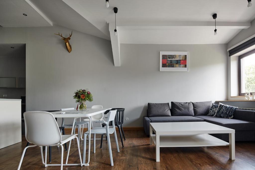 sala de estar con sofá, mesa y sillas en PlayHouse Apartments, en Cracovia
