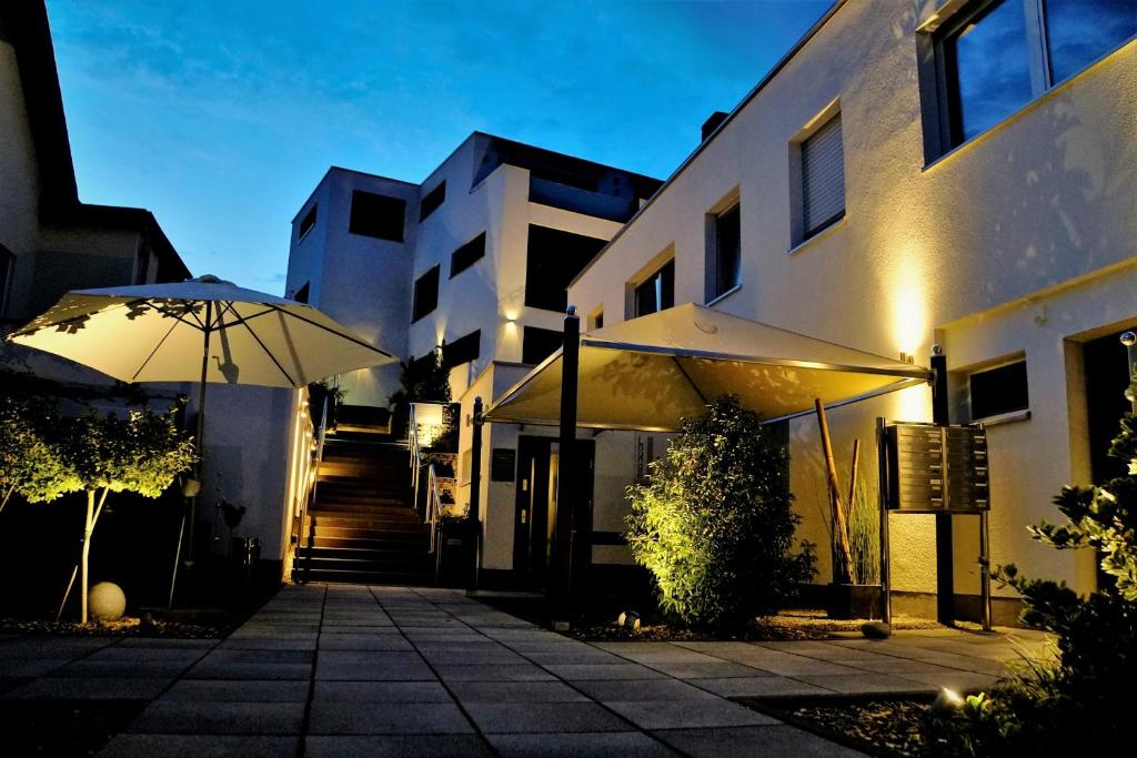 a building with an umbrella in front of it at WohnRaum Hotel & Gästehaus in Gusterath