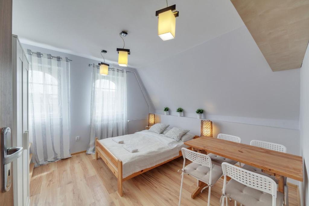een kamer met een bed, een tafel en stoelen bij Dream Loft Motlava River in Gdańsk