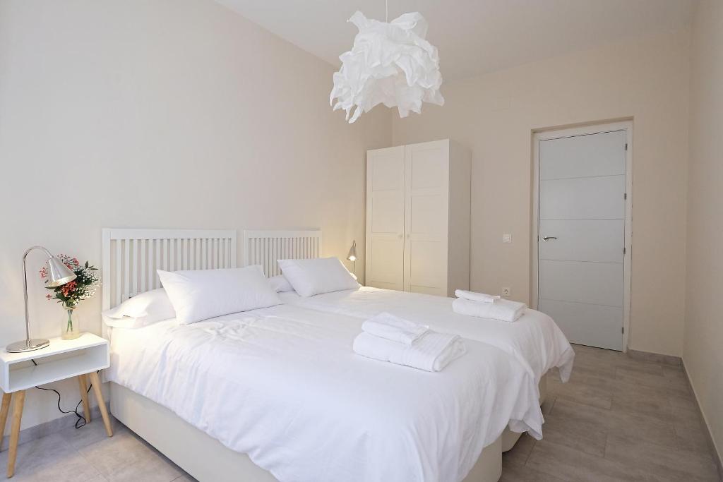 1 dormitorio blanco con 1 cama blanca grande con almohadas blancas en CSE San Miguel, en Sevilla