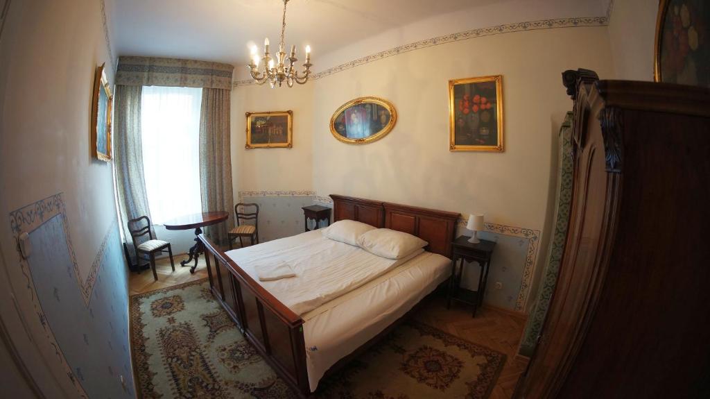 um quarto com uma cama e um lustre em Vavelsky Apartments - Old Town em Cracóvia