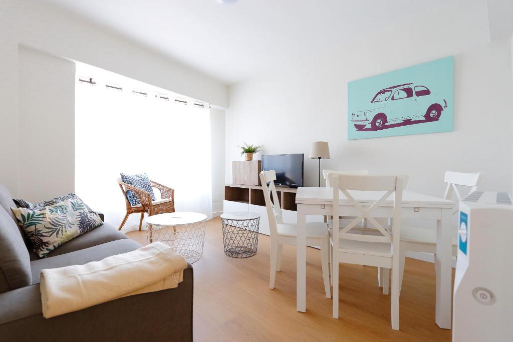 a living room with a table and a white dining room at Apartamento Cabrales in Gijón
