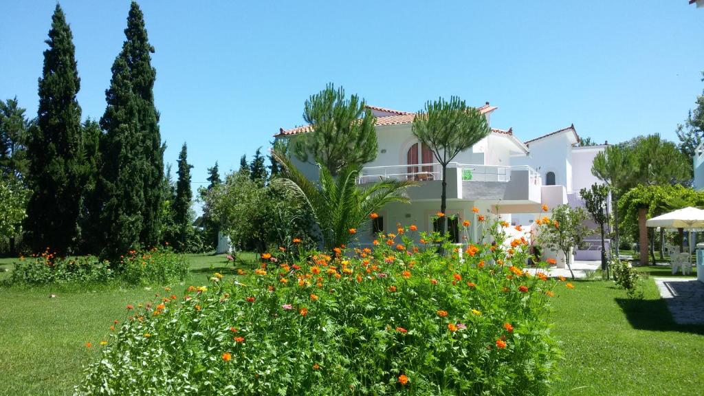a house with a garden with flowers in front of it at Chroma Studios in Oreoi