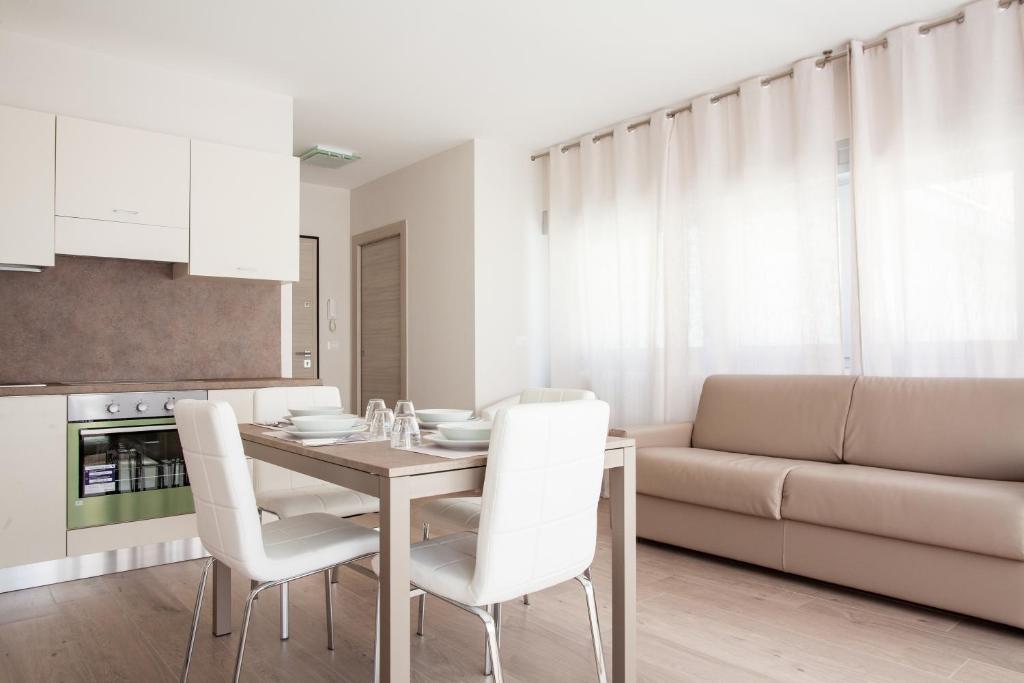 ボローニャにあるAstoria Suite Apartmentsのキッチン、ダイニングルーム(テーブル、白い椅子付)