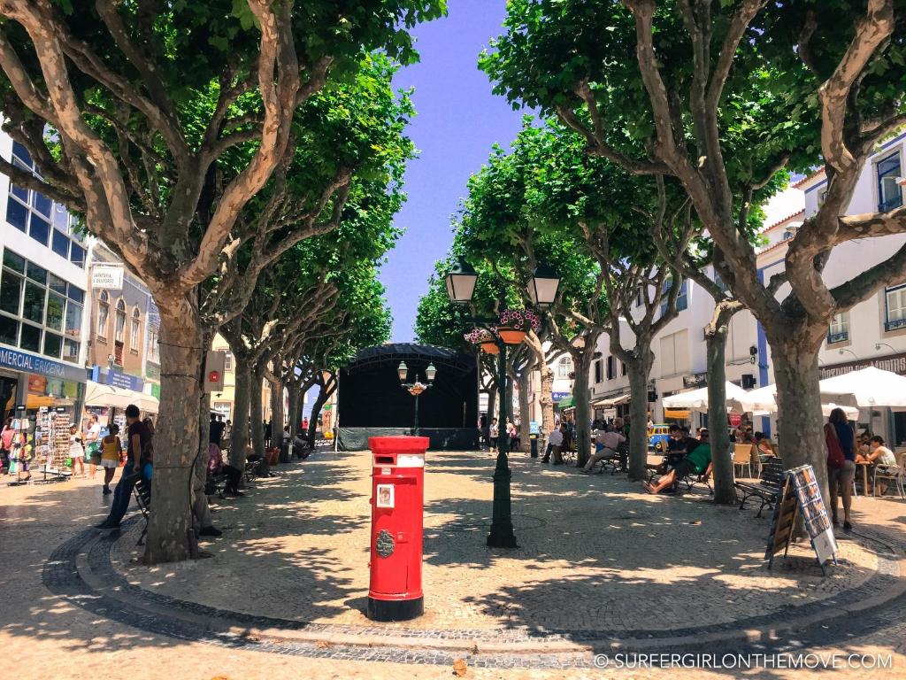 a street with trees and a red post box at Ericeira Surf and Sun in Ericeira