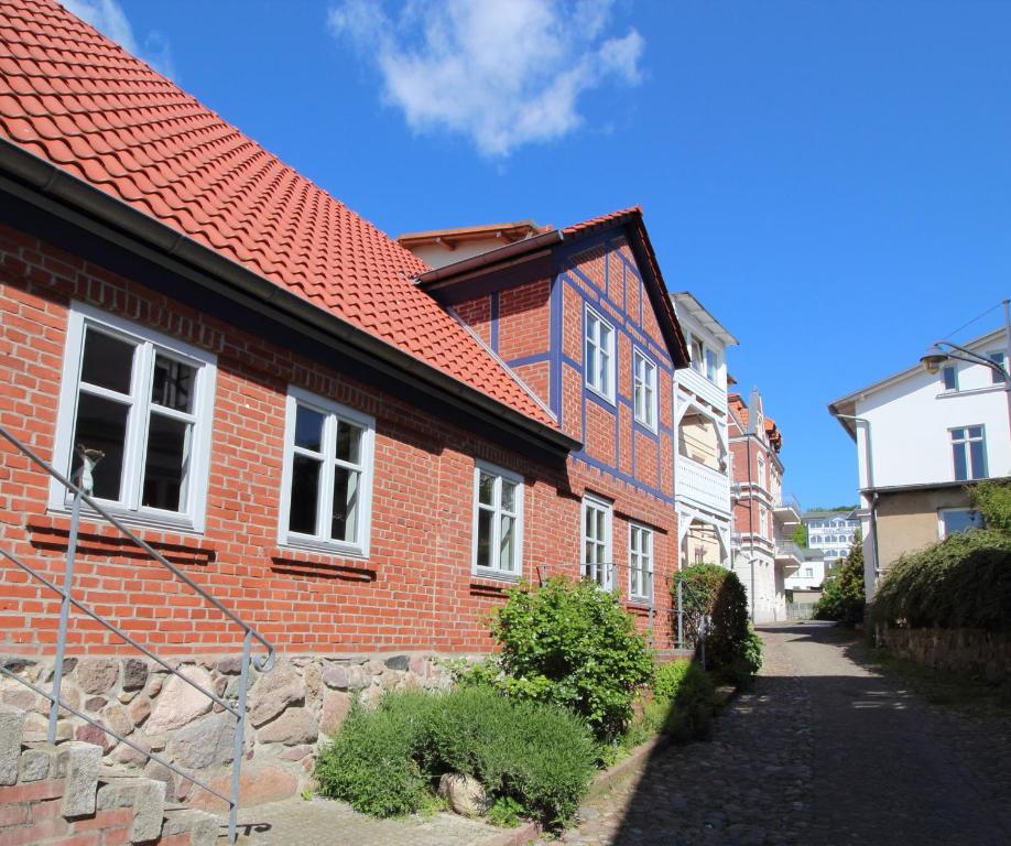 a brick house with a red roof on a street at Ferienwohnung Zum Strandvoigt in Sassnitz