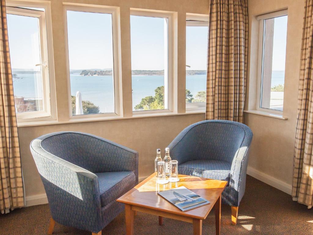 two chairs and a table in a room with windows at Harbour Heights Hotel in Poole