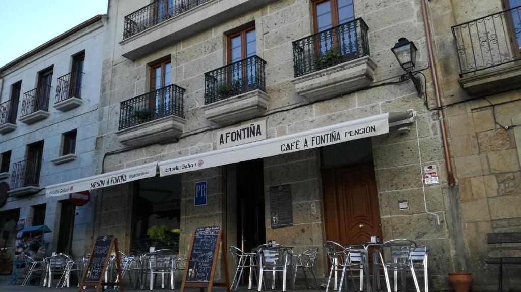 un edificio con mesas y sillas fuera de él en Pension a Fontiña, en Cuntis