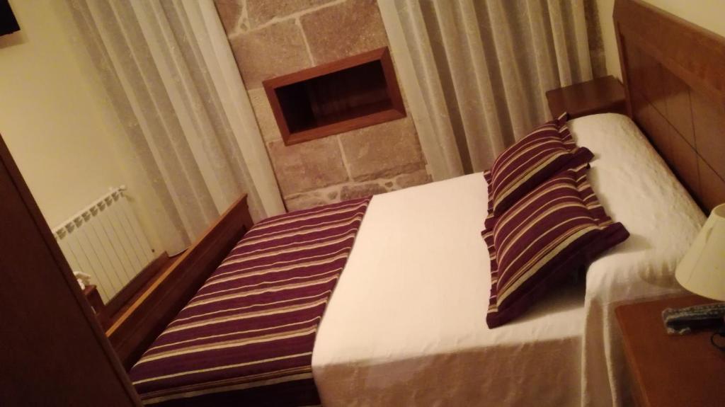 A bed or beds in a room at Pension a Fontiña