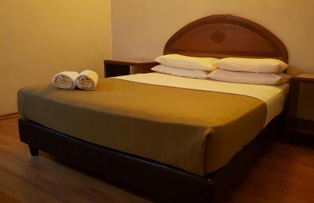 um quarto com uma cama com duas toalhas em the coconut langkawi em Pantai Cenang
