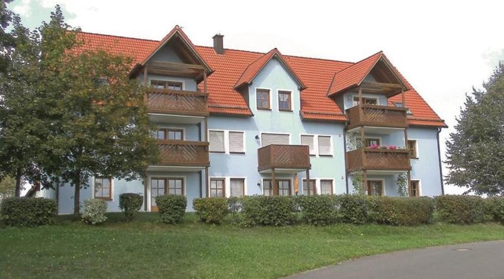 una grande casa con tetto arancione di Ferienwohnung Am Sonnenhang a Neualbenreuth