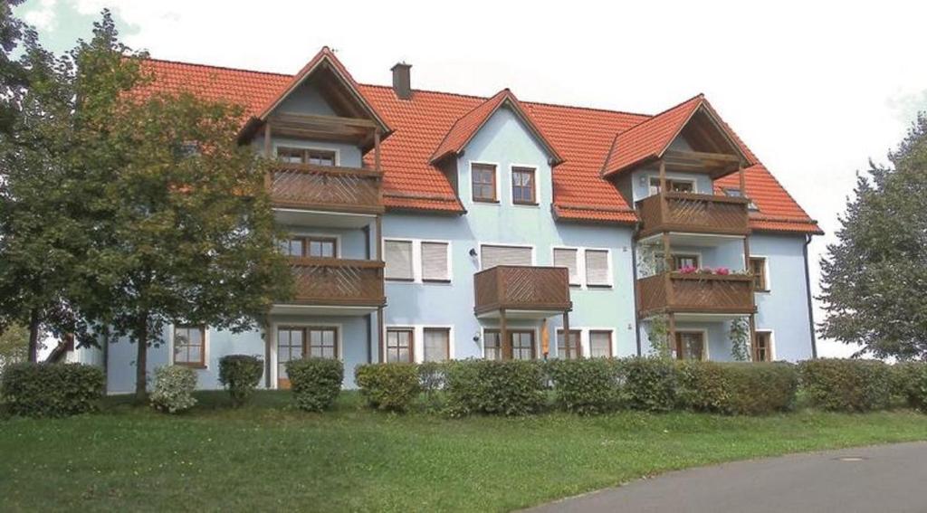 a large house with an orange roof at Ferienwohnung Am Sonnenhang in Neualbenreuth