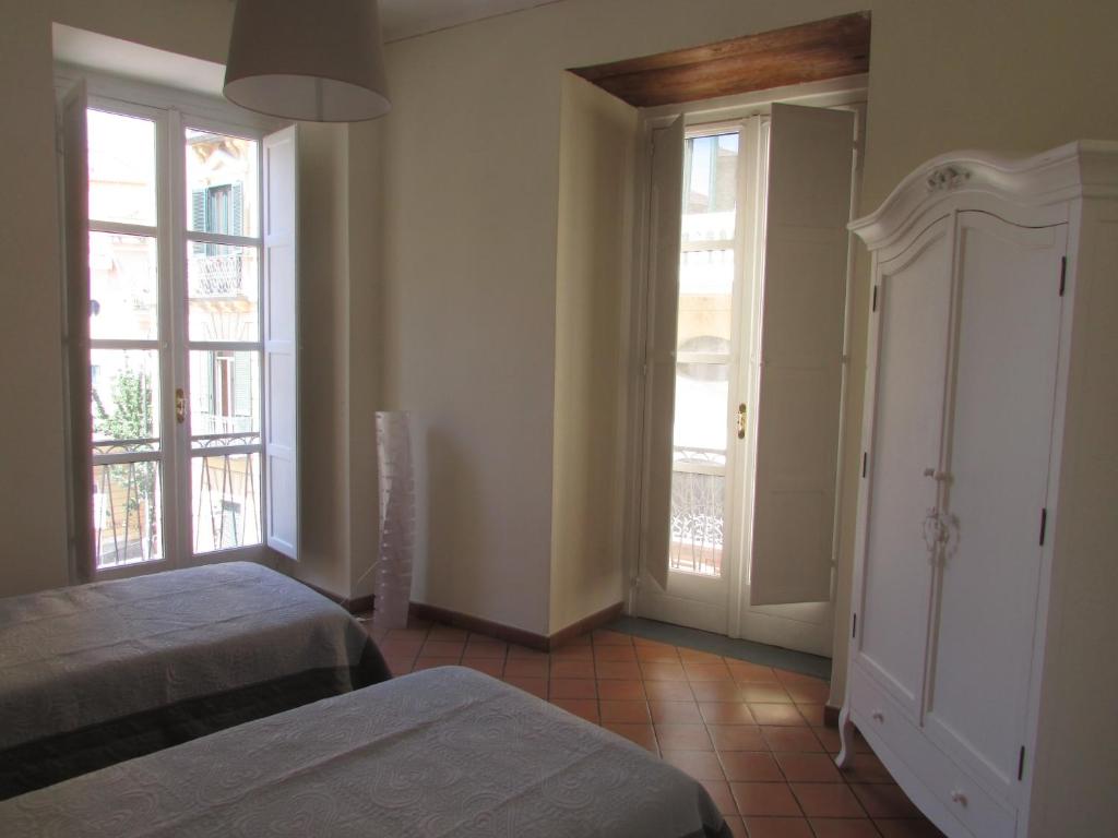 薩雷諾的住宿－Salerno Domus Claudia，一间卧室设有两张床和两个窗户。