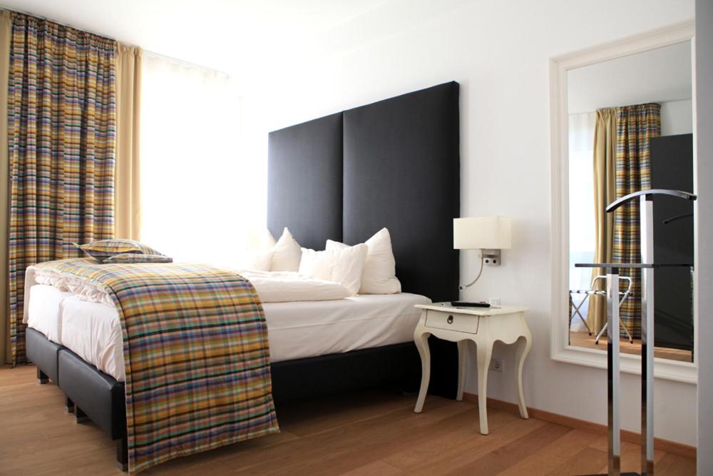 a hotel room with a bed and a side table at Stein Boardinghouse in Koblenz